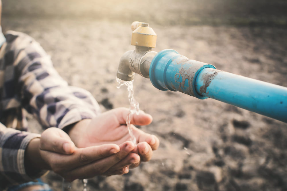 mani che cercano acqua, segno della crisi idrica in Italia