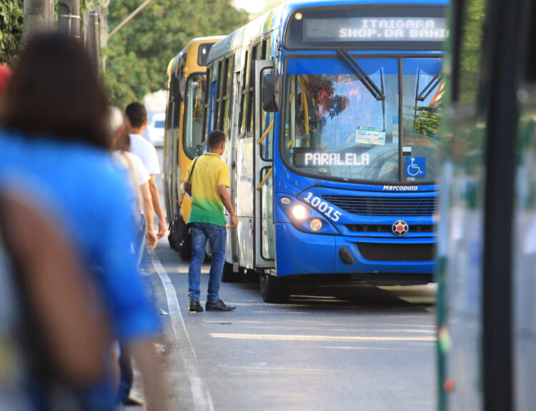 Persone che attendono l'autobus come parte della mobilità urbana. Un autobus blu si ferma per far salire i passeggeri in una strada cittadina.