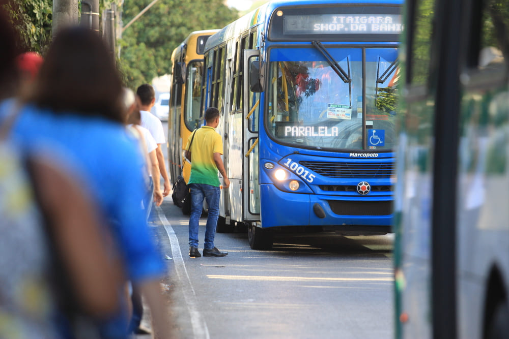 Persone che attendono l'autobus come parte della mobilità urbana. Un autobus blu si ferma per far salire i passeggeri in una strada cittadina.